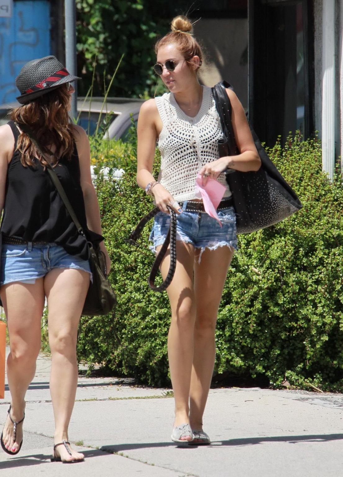 10P Miley Cyrus wearing denim shorts  c-thru lace top in Beverly Hills