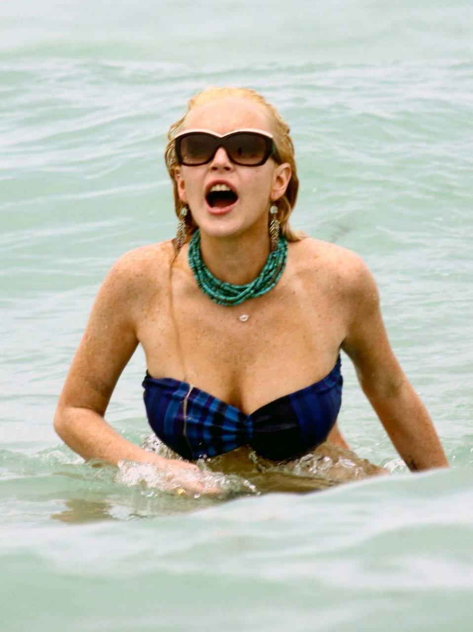 16P Lindsay Lohan tits slip from bikini on beach oops paparazzi pictures