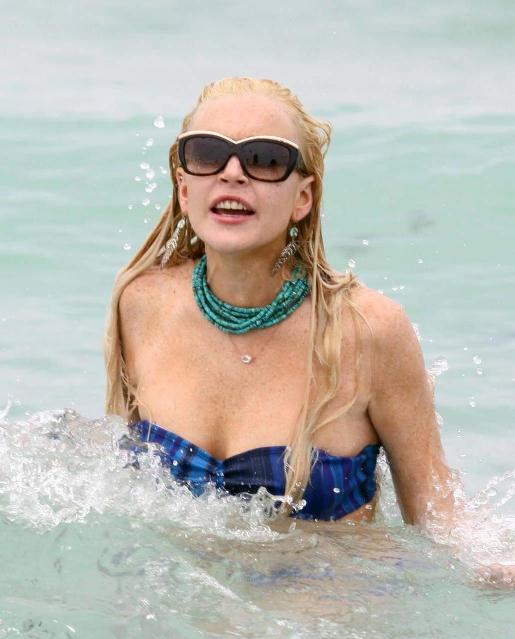 16P Lindsay Lohan tits slip from bikini on beach oops paparazzi pictures