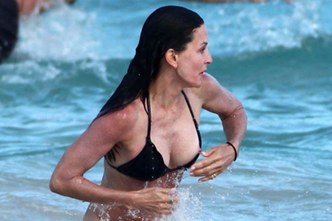 16P Courteney Cox nipple slip and looking very sexy in black bikini on beach paparaz