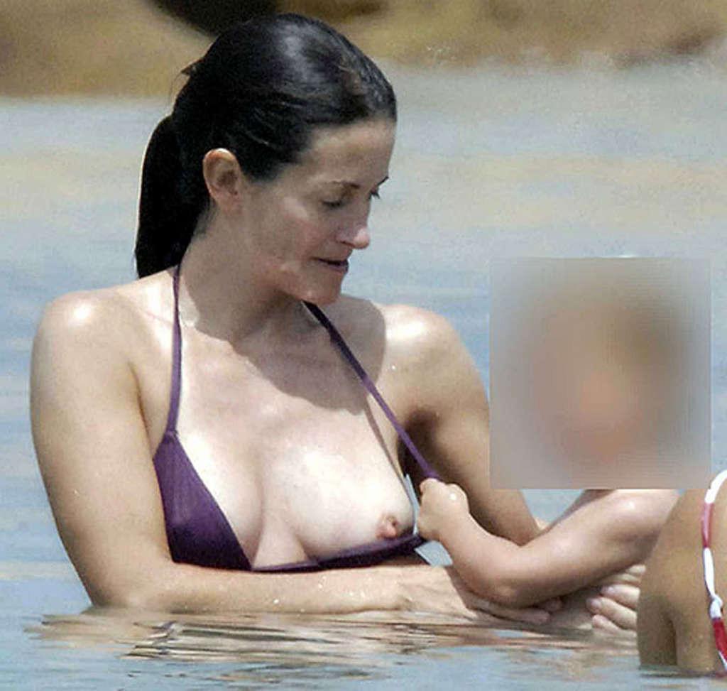 16P Courteney Cox very leggy in mini skirt and tits slip in water