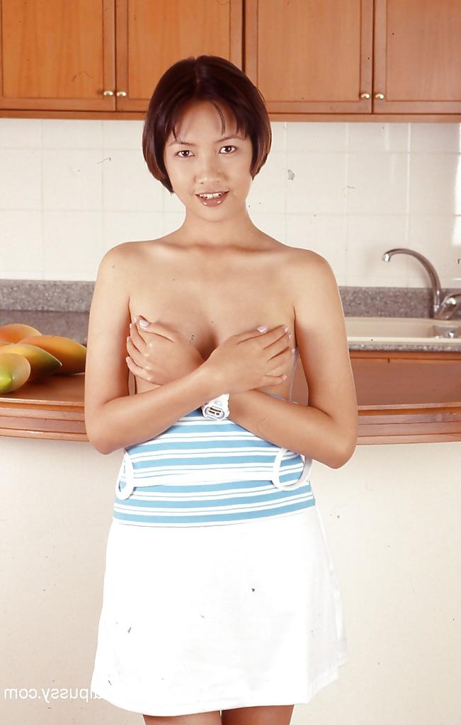 16P Clothed Asian with tiny tits is posing in the kitchen with spread legs