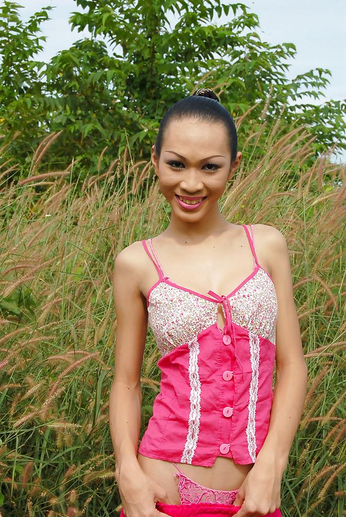 16P Skinny Asian ladyboy Deer showing off big tits and tight ass outdoors