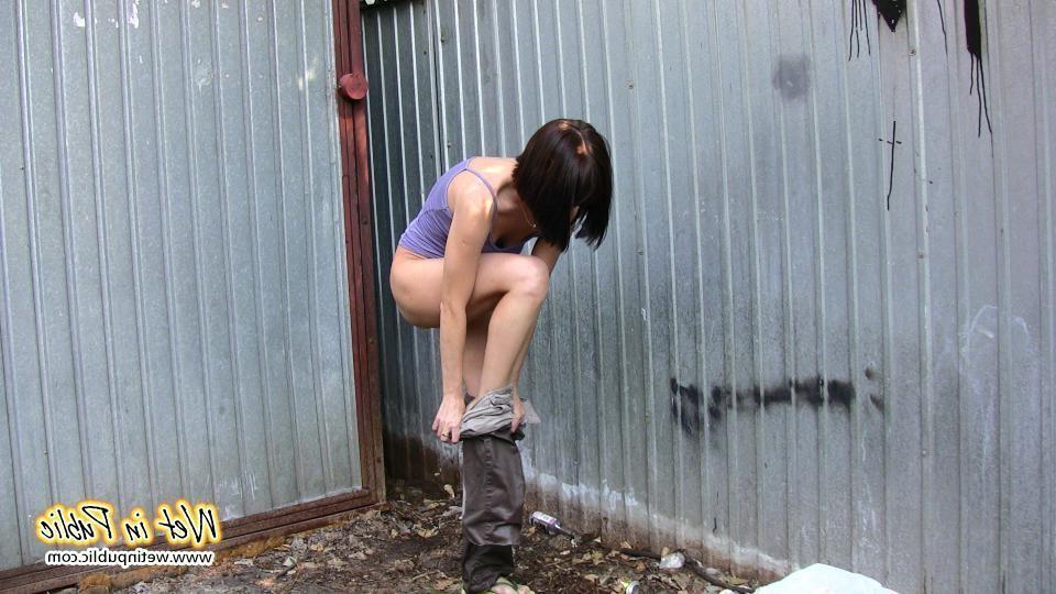 16P Amateur chick standing on a sidewalk and shamelessly pissing her pants