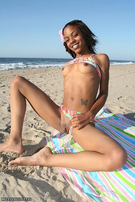 16P Petite ebony chick getting naked and posing on the beach