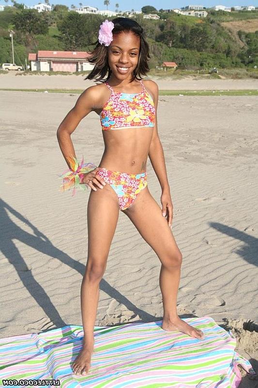 16P Petite ebony chick getting naked and posing on the beach