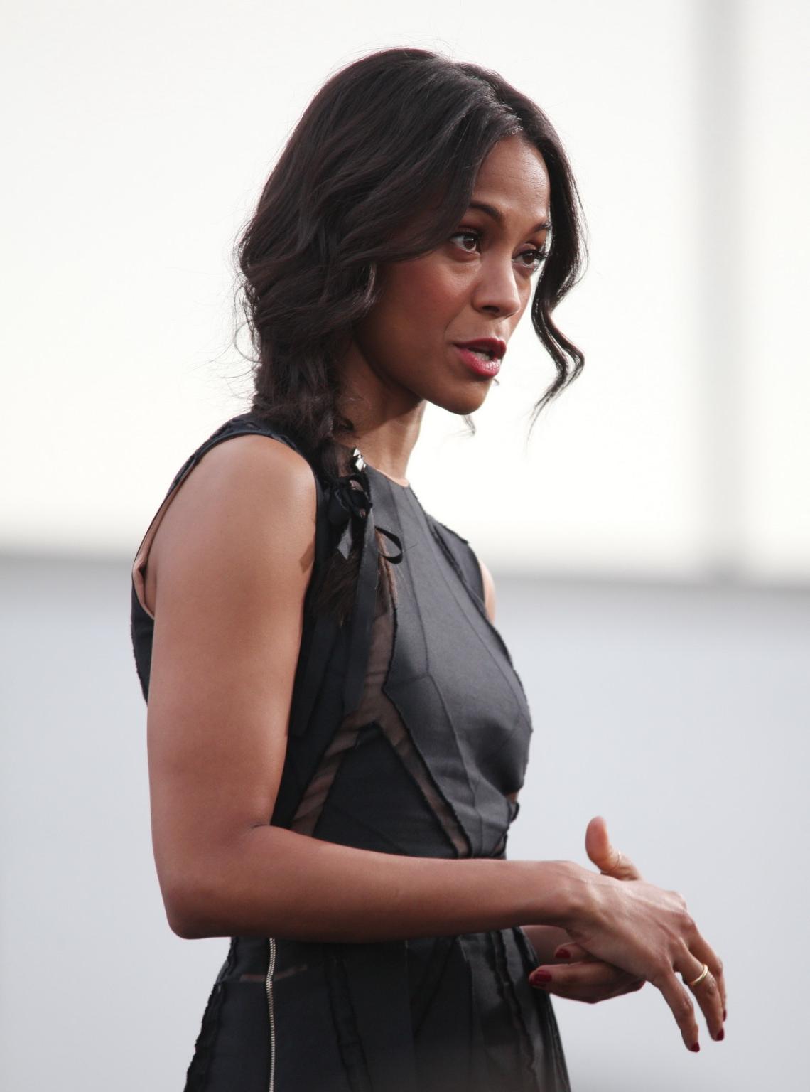 16P Zoe Saldana wearing black partially see-through mini dress on 'Extra' set at the