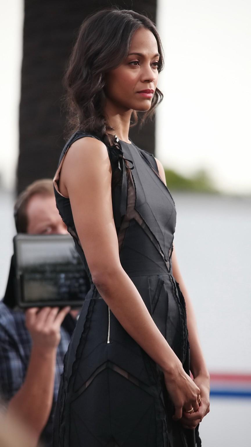 16P Zoe Saldana wearing black partially see-through mini dress on 'Extra' set at the
