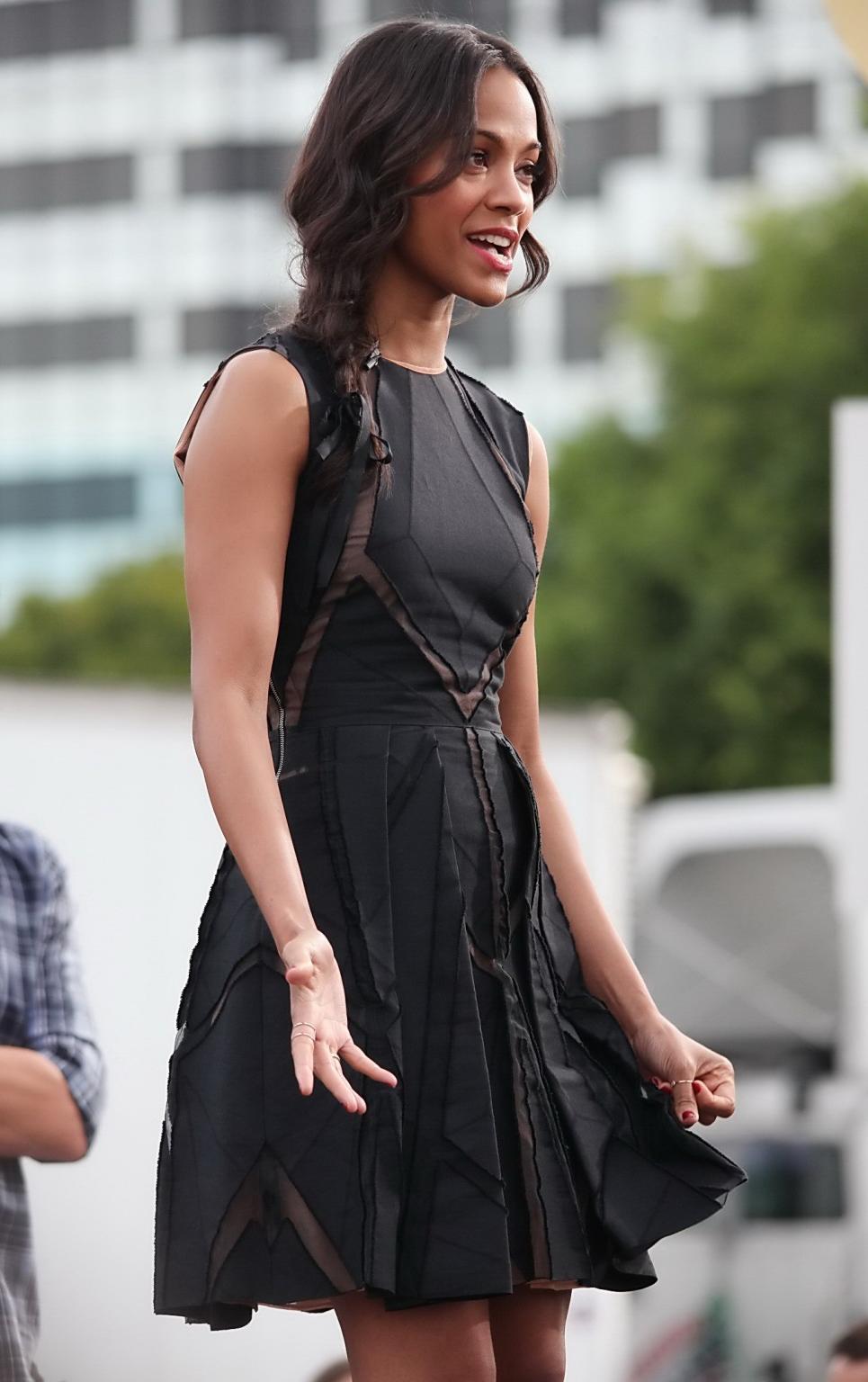 16P Zoe Saldana wearing black partially see-through mini dress on 'Extra' set at the