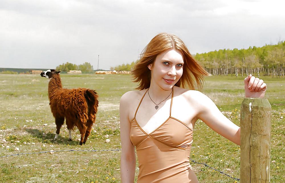 13P Blond teen strips infron of a fence for llamas
