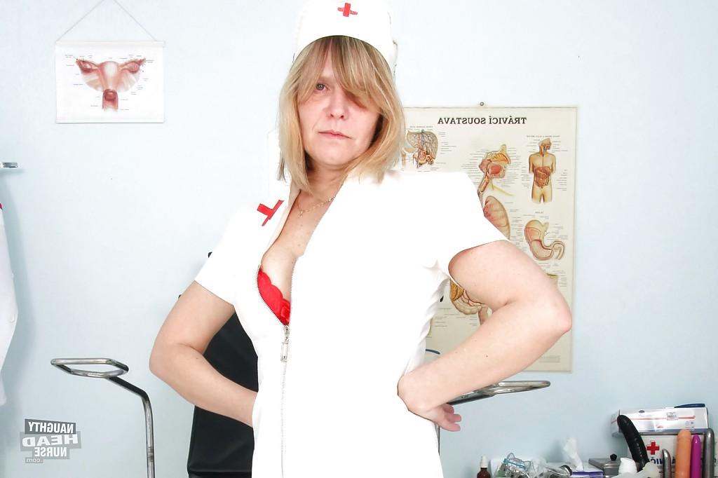 16P Raunchy mature lady in nurse uniform and stockings revealing her twat