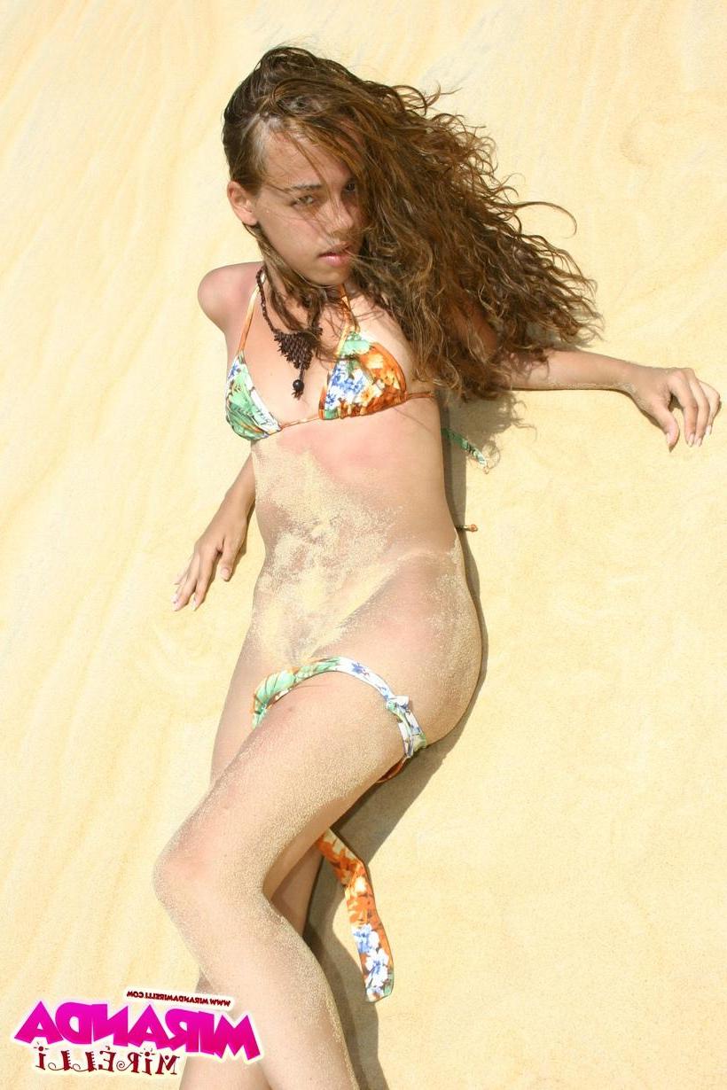 16P Miranda Mirelli lies down and stretches out on the hot white sand dunes