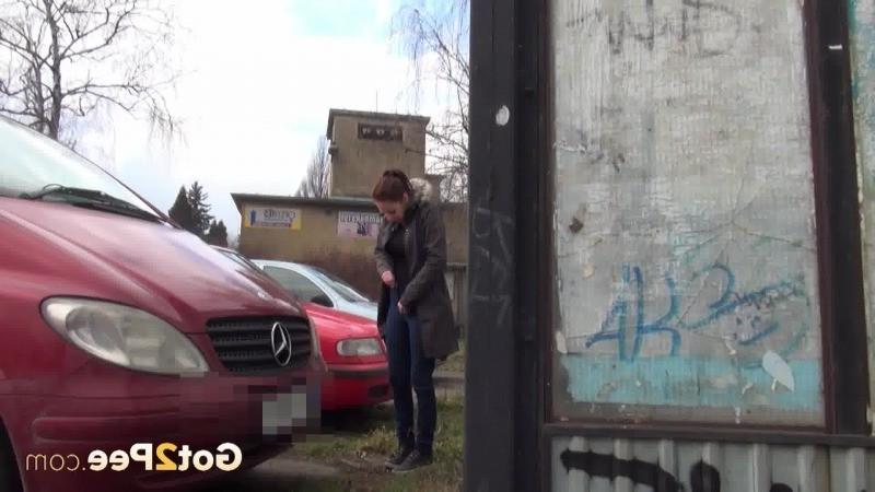 15P Sexy brunette babe pisses behind a bus stop