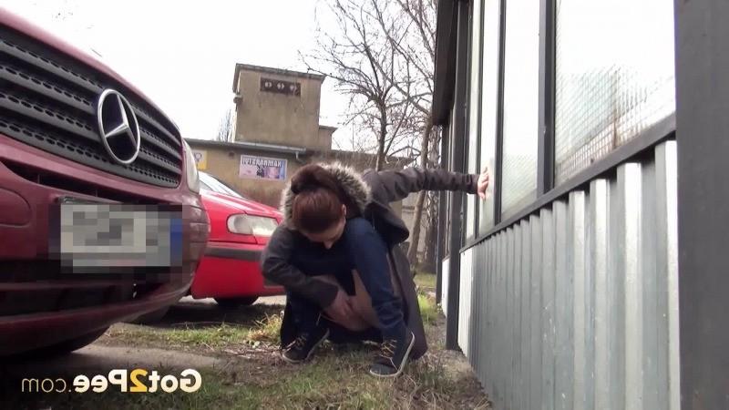 15P Sexy brunette babe pisses behind a bus stop