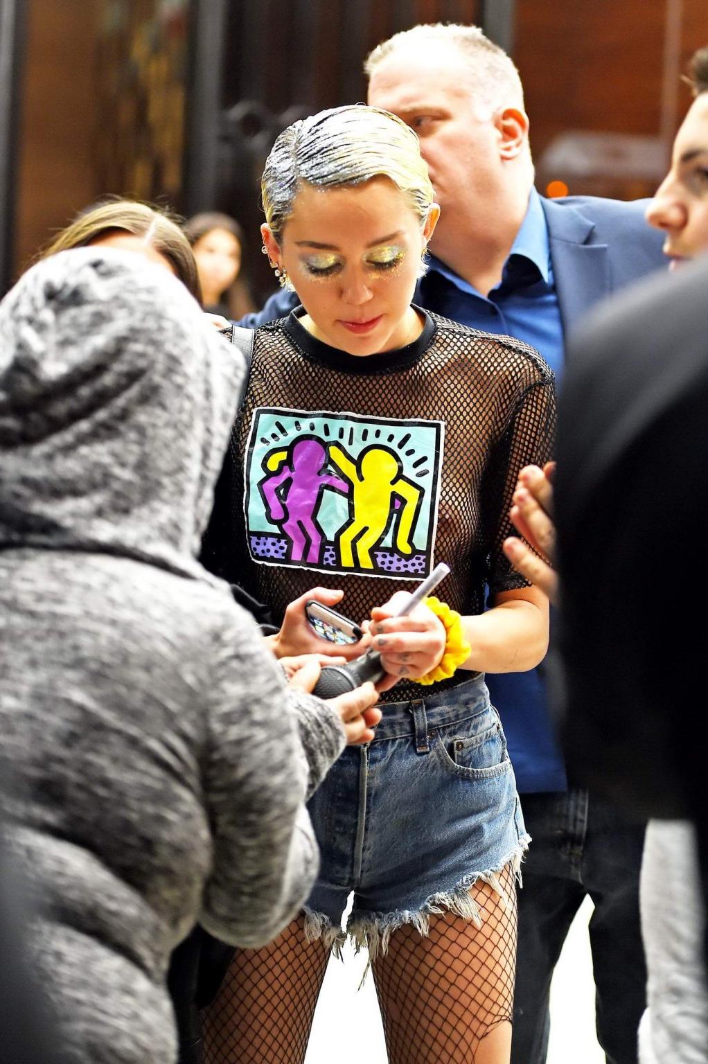 16P Miley Cyrus shows off her boobs wearing a mesh Tshirt out in NYC