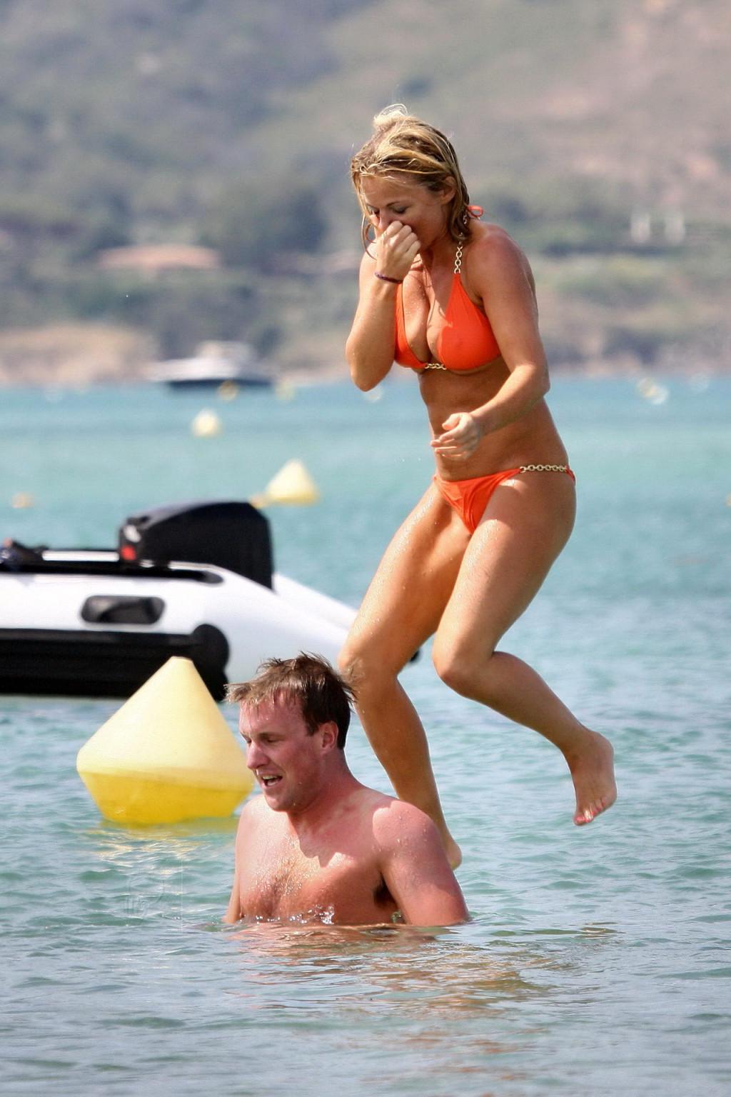 15P Busty Geri Halliwell showing pokies in skimpy orange bikini at Club 55 beach in 