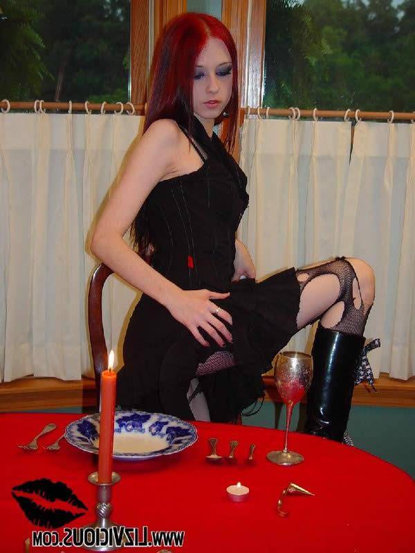 18P Goth chick in torn fishnet stockings plays on the table