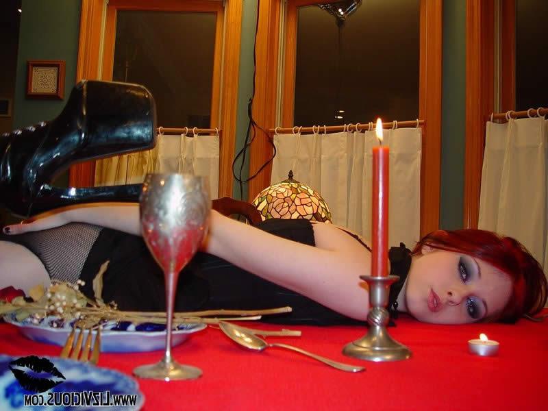 18P Goth chick in torn fishnet stockings plays on the table