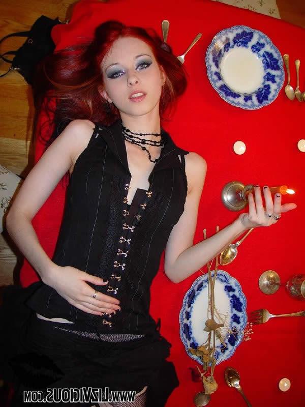 18P Goth chick in torn fishnet stockings plays on the table