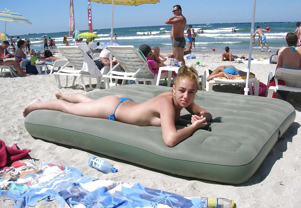 20P Young girl topless at the beach.