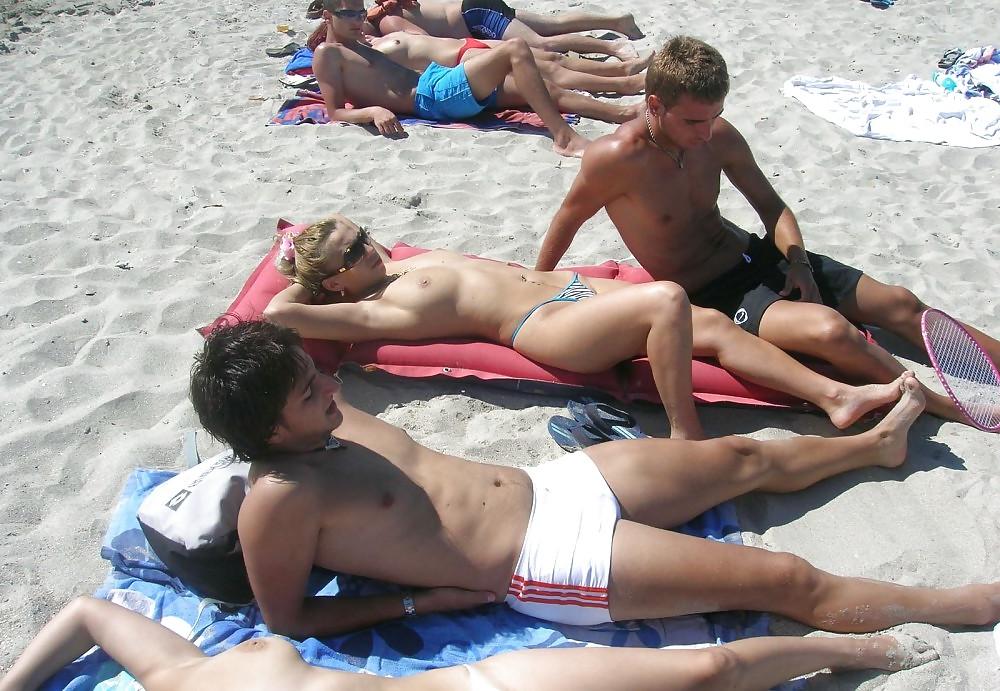 20P Young girl topless at the beach.