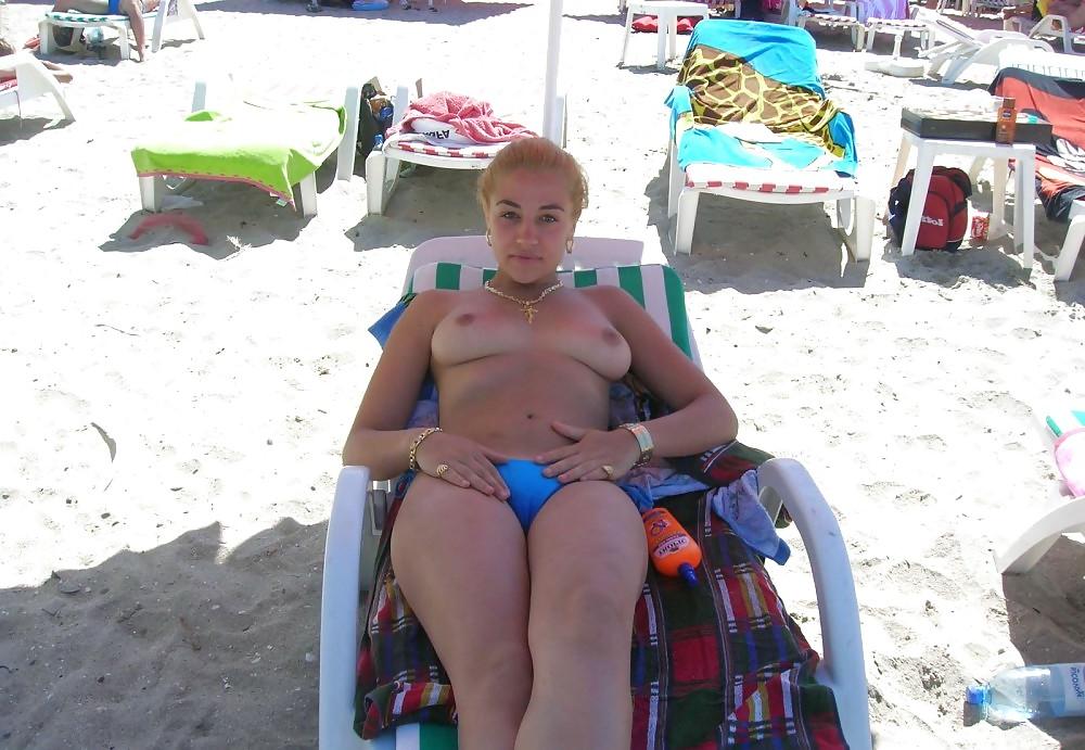 20P Young girl topless at the beach.