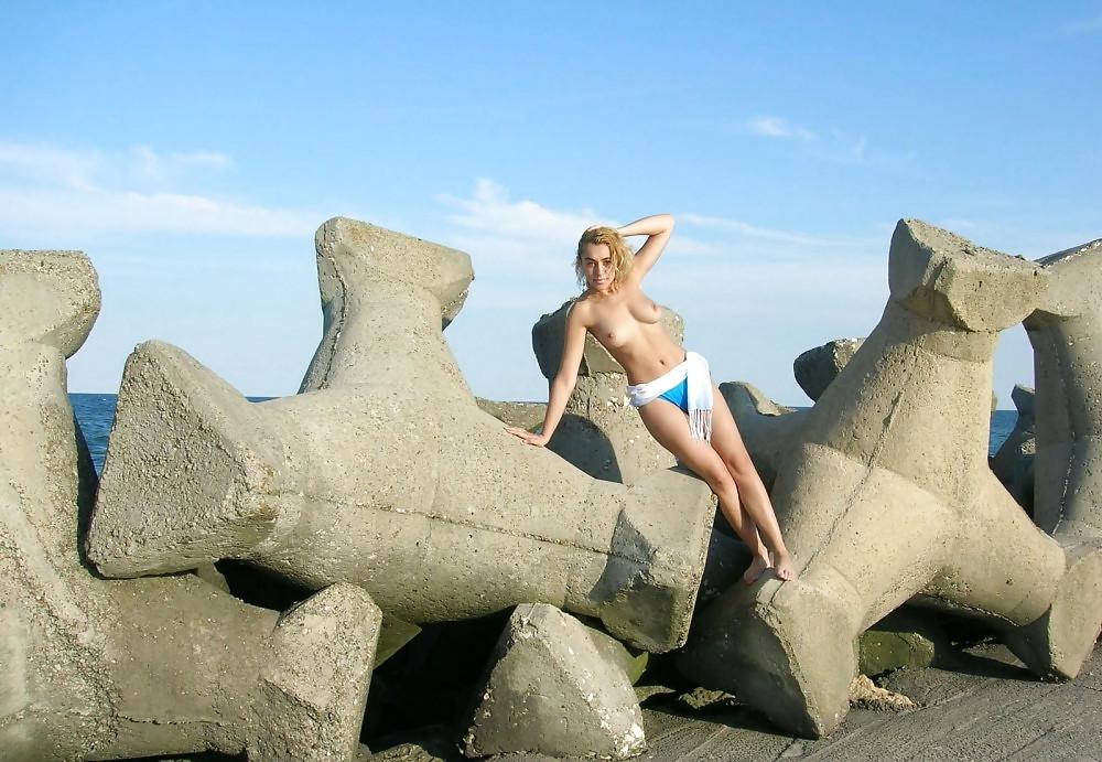 20P Young girl topless at the beach.