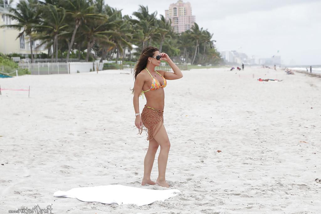 16P Mature woman Nina Dolci letting firm tits free from bikini on beach