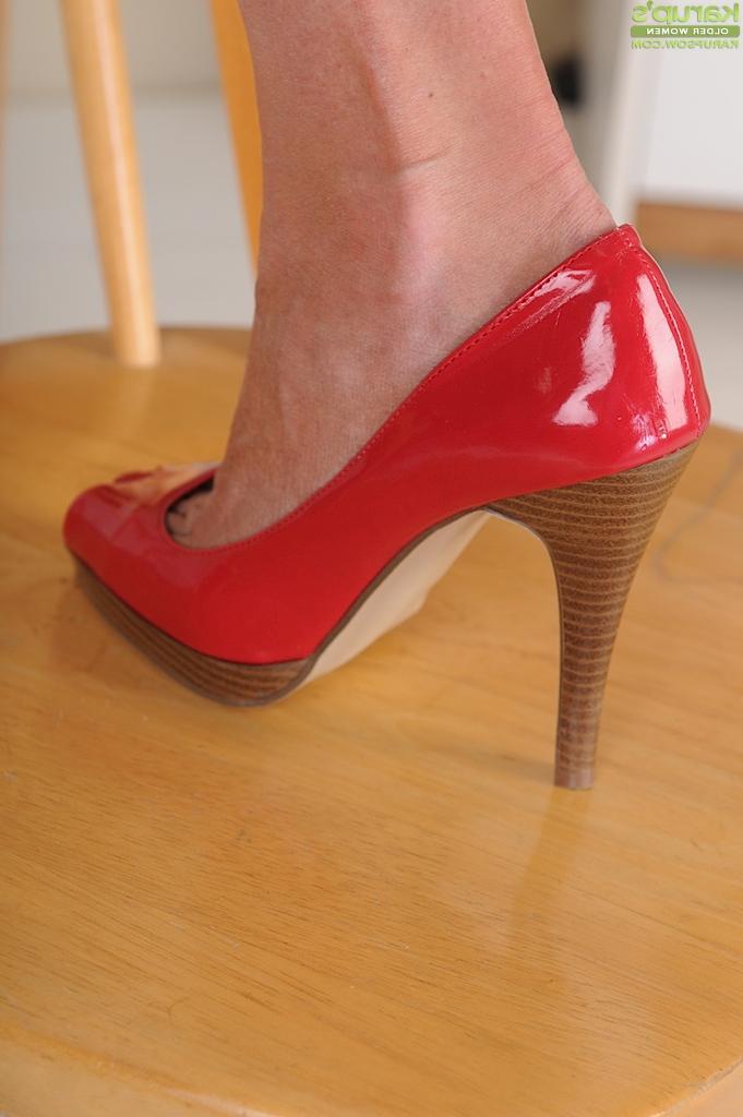 16P Older blonde woman Liz Summers removing red pumps to show off sexy feet