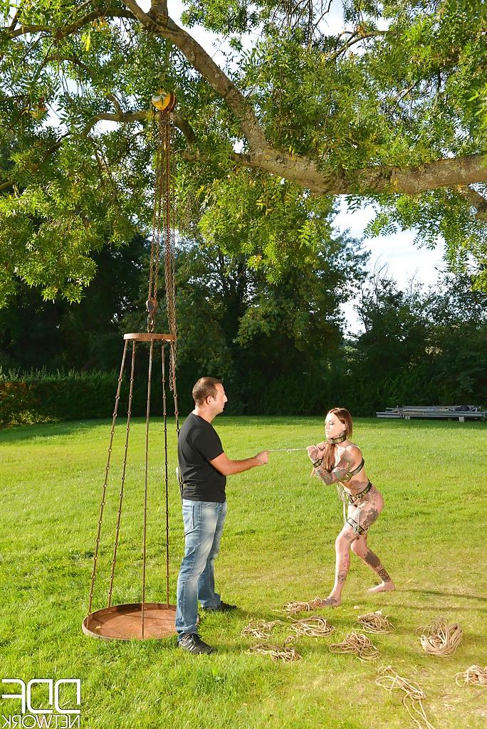 16P Inked fetish model undergoing outdoors slave training in collar