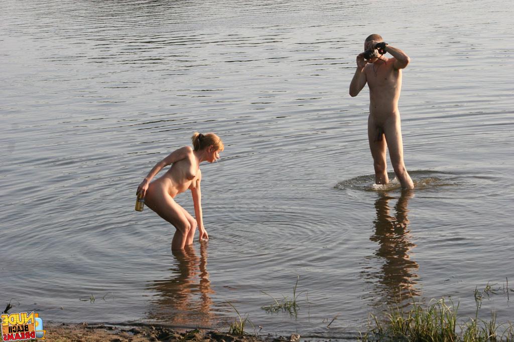 15P A couple walks through the water and kisses on the beach