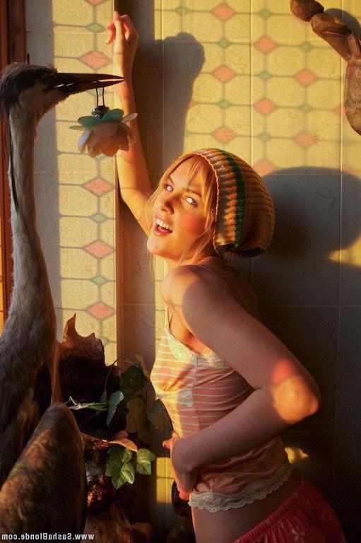 15P Topless blonde poses at stained-glass window