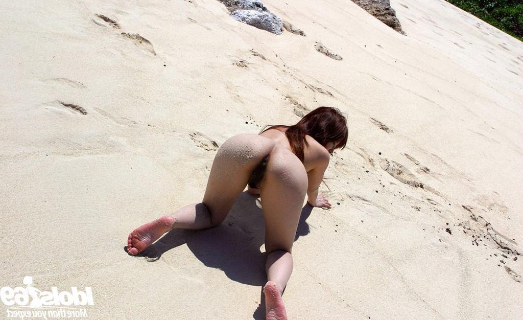 15P Cute petite Asian shows hairy pussy on sandy beach