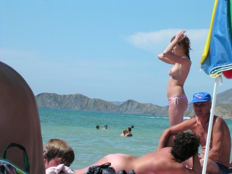 15P Young nudist shows off her slim body at the beach