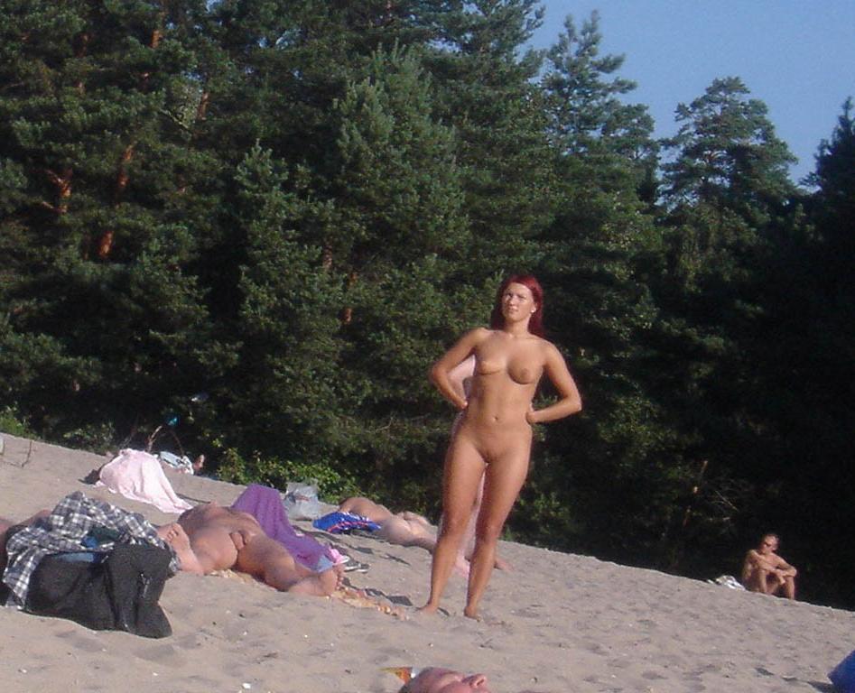 15P Blonde nudist kicks up some water at a nude beach