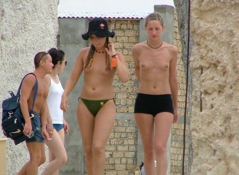15P Blonde nudist kicks up some water at a nude beach