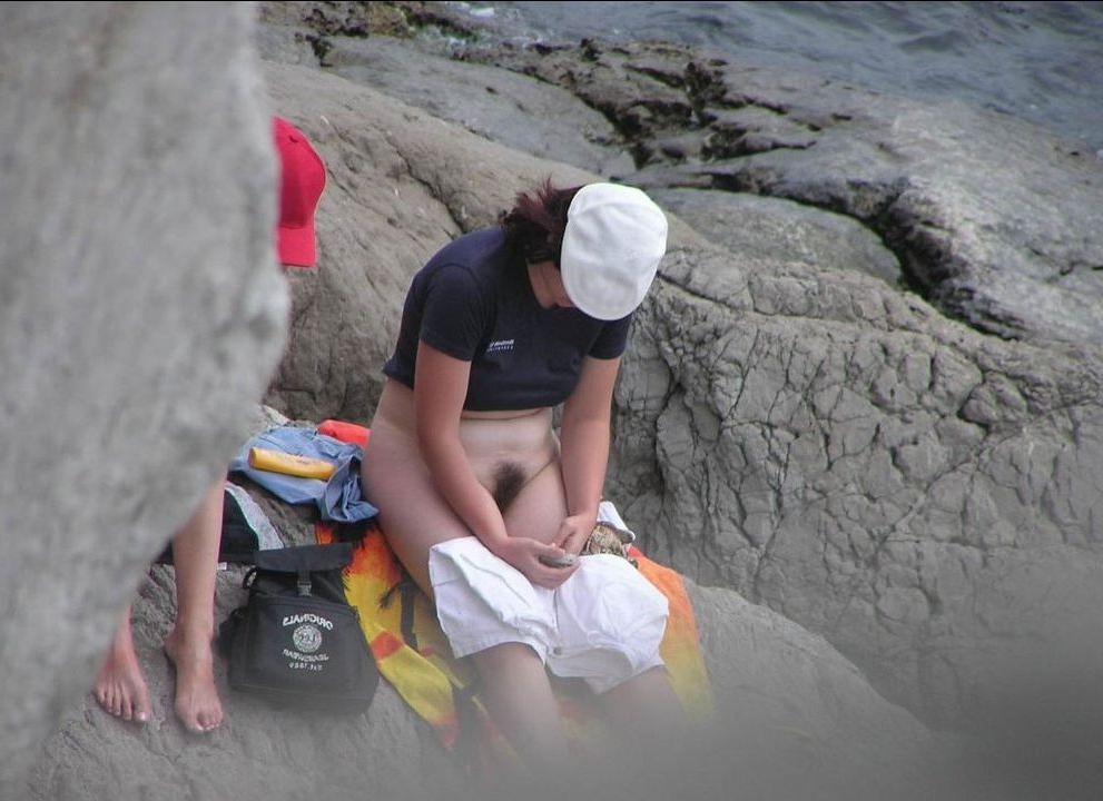 15P Blonde nudist kicks up some water at a nude beach