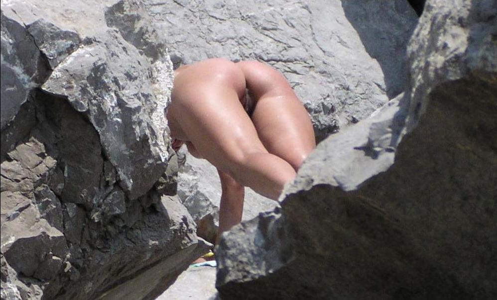 15P Blonde nudist kicks up some water at a nude beach