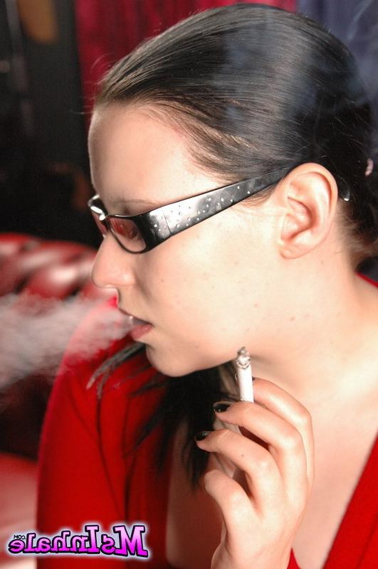 16P Cute teen in glasses smokes a menthol cigarette