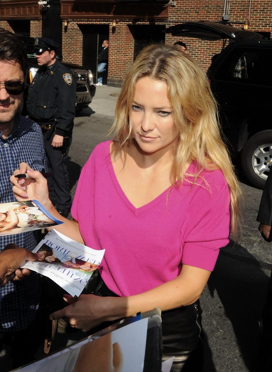 16P Kate Hudson cleavy and leggy in a pink top and tight short leather skirt arrivin