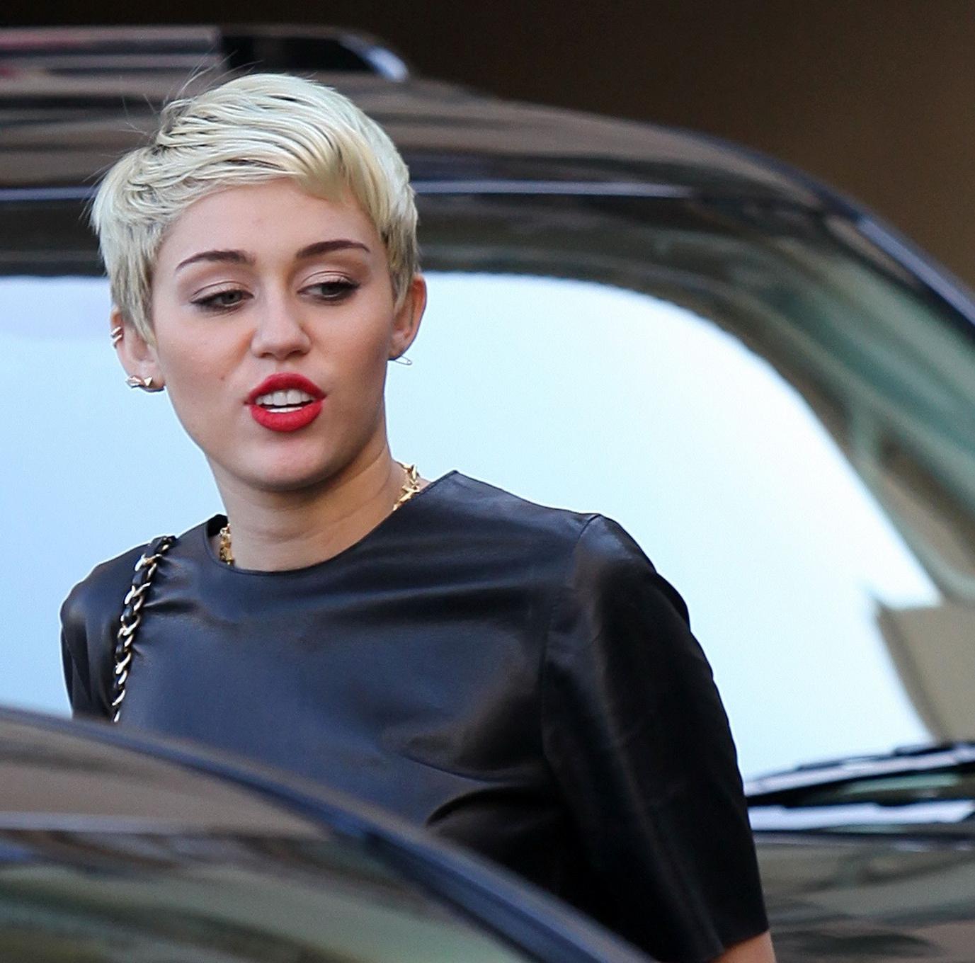 16P Miley Cyrus leggy wearing a denim shorts  a leather top out in Beverly Hills