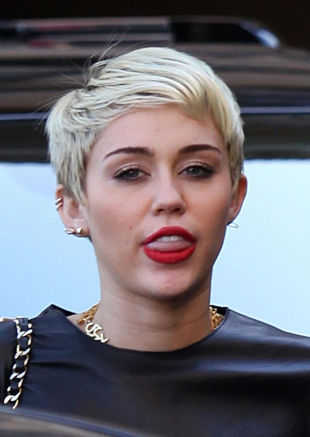 16P Miley Cyrus leggy wearing a denim shorts  a leather top out in Beverly Hills