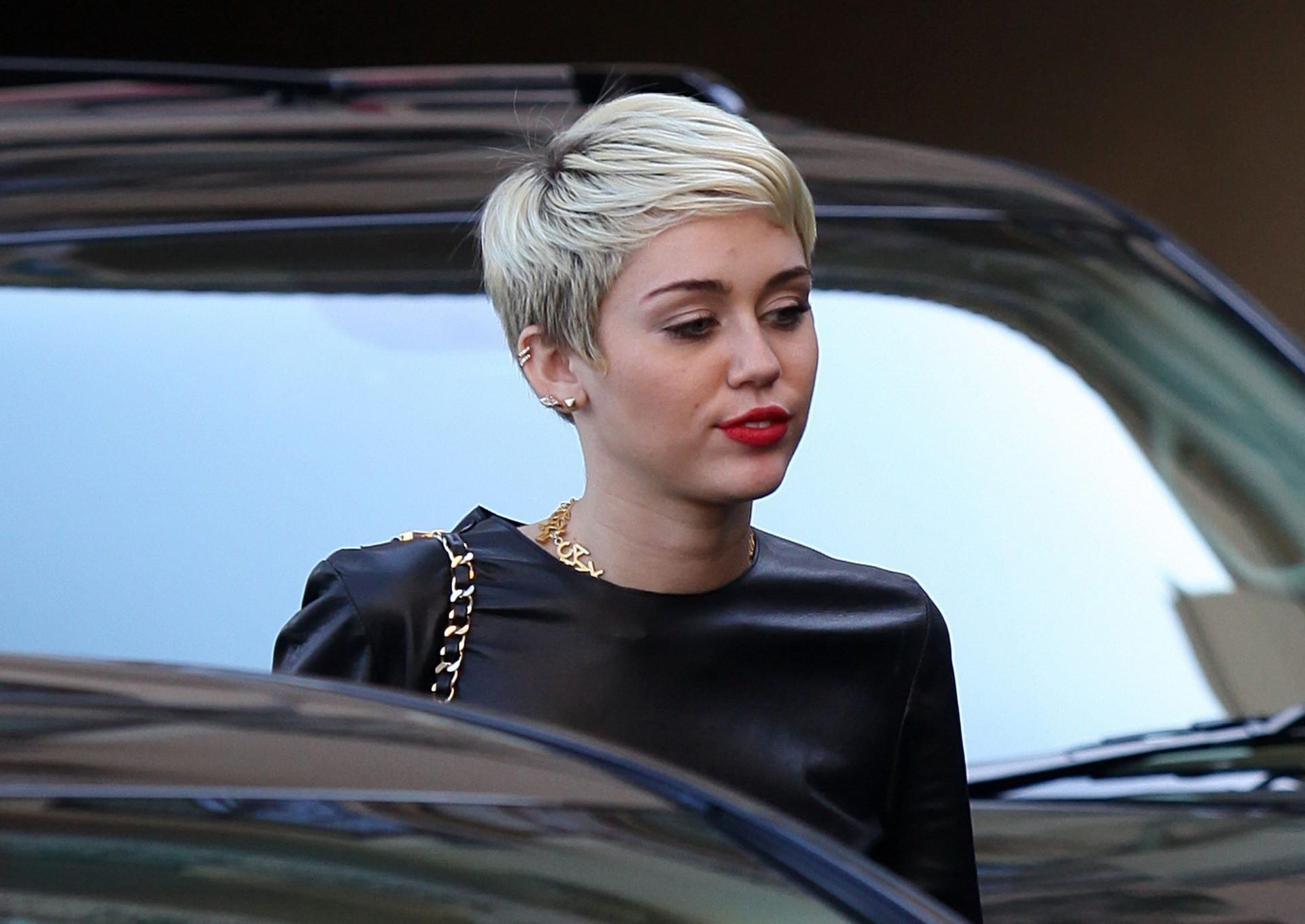 16P Miley Cyrus leggy wearing a denim shorts  a leather top out in Beverly Hills