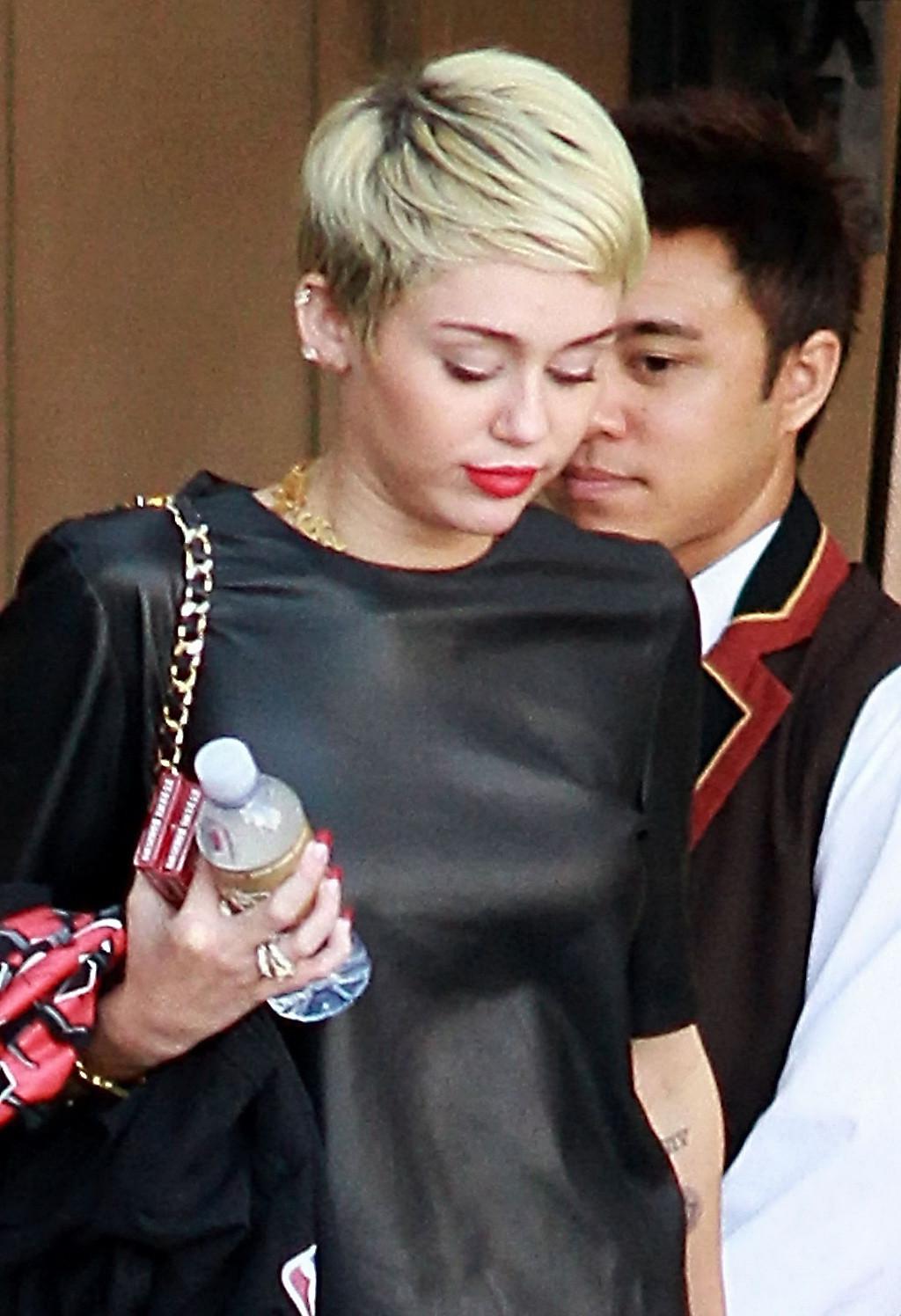 16P Miley Cyrus leggy wearing a denim shorts  a leather top out in Beverly Hills