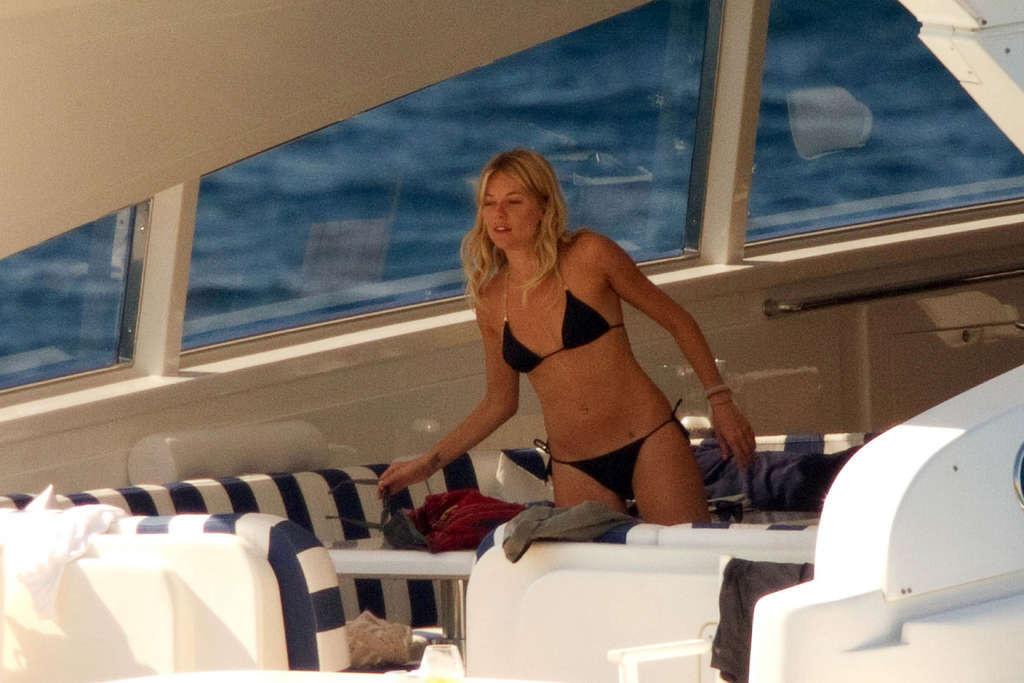16P Sienna Miller exposing her sexy body and hot ass in black bikini on yacht