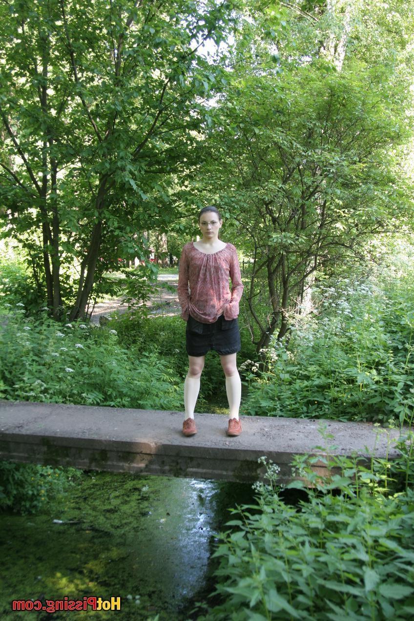 15P Blushing chick in glasses does a great pee stream from the park bridge