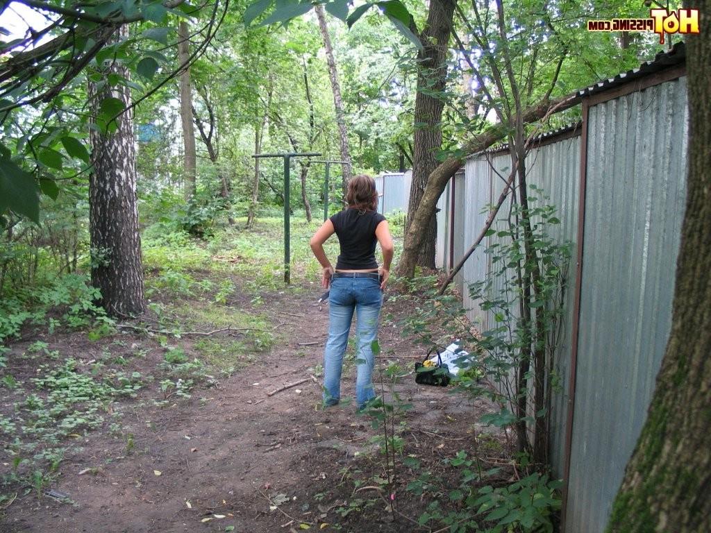 15P Spy camera shots of a gal in jeans as she does a leak behind a garage