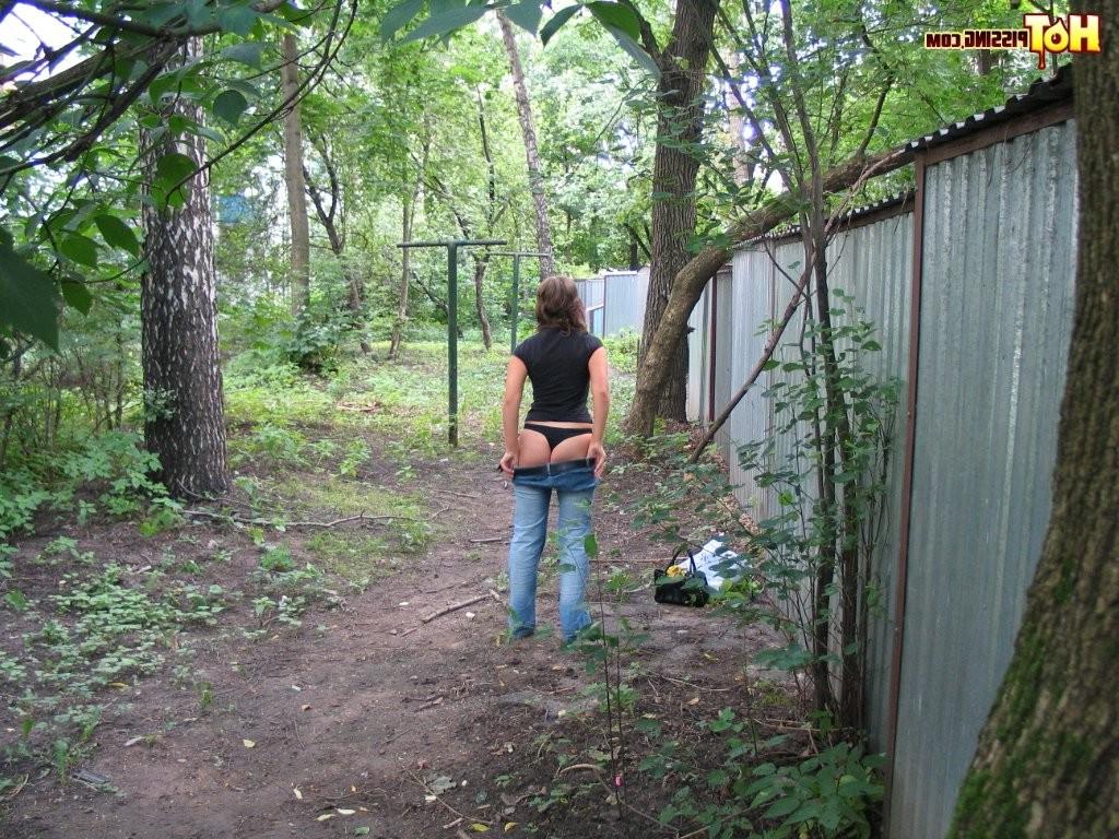 15P Spy camera shots of a gal in jeans as she does a leak behind a garage