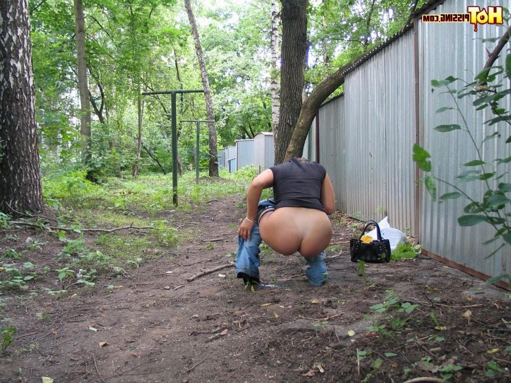 15P Spy camera shots of a gal in jeans as she does a leak behind a garage