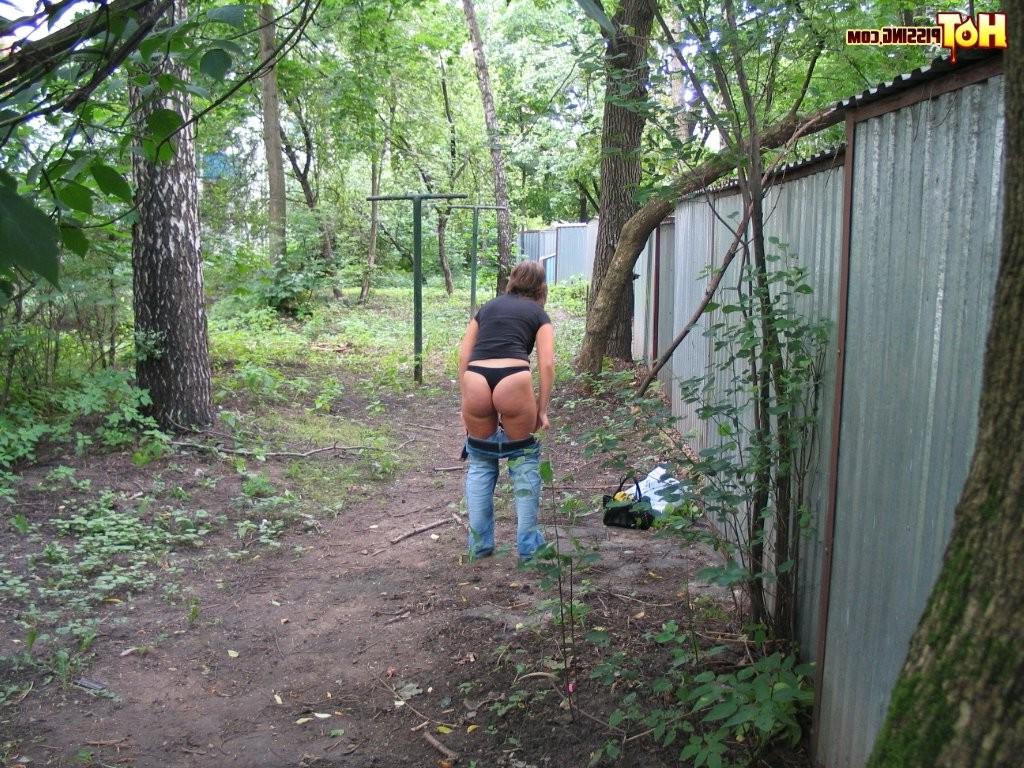15P Spy camera shots of a gal in jeans as she does a leak behind a garage